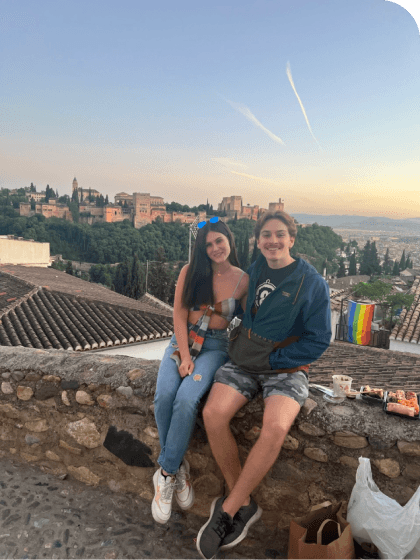 Sitting on a wall on the side of the road with my partner Bailey, overlooking Granada, Spain